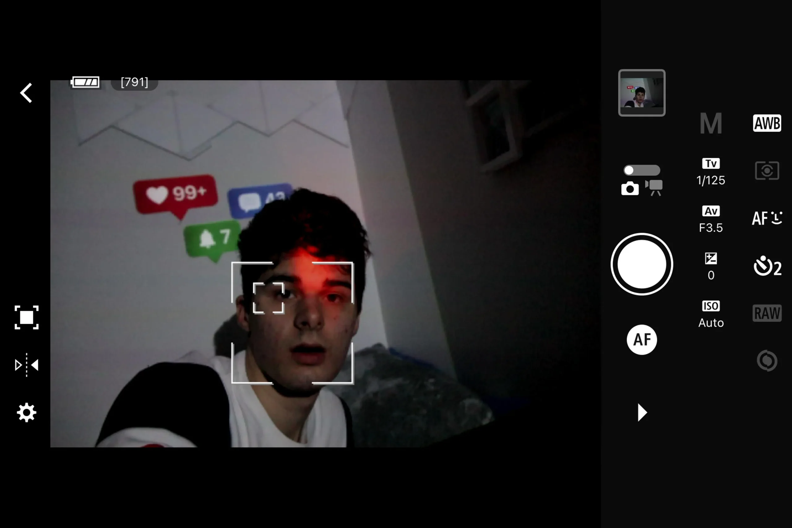 Autoportrét v rozhraní dálkového ovládání fotoaparátu s projekcí upozornění ze sociálních sítí.
